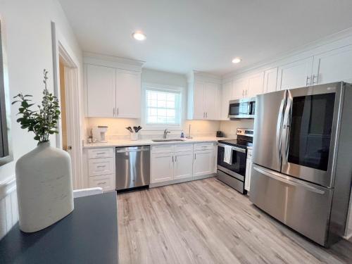 a kitchen with white cabinets and stainless steel appliances at Adjacent 2nd Floor, 2004 Queen & 2005 Queen in Surf City