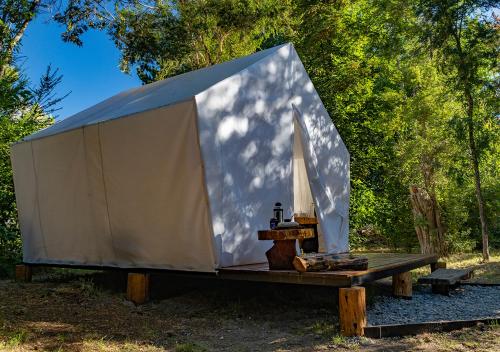 a tent with a sail on top of a bench at Costa del Río in Lago Puelo