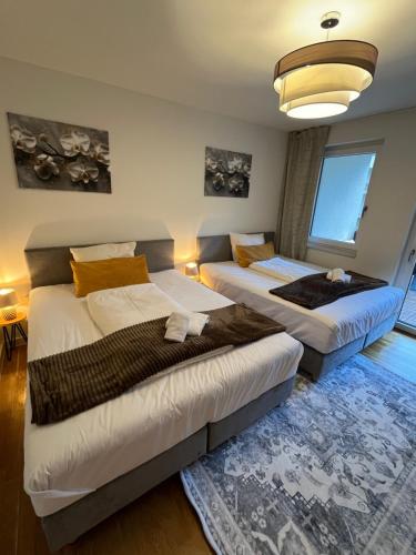 a bedroom with two beds and a large window at UNiQE Apartments Oldtown - citycenter in Dresden