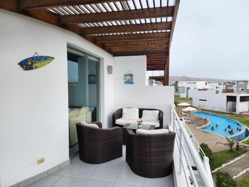 a balcony with a table and chairs and a pool at Condominio Las Terrazas in Asia