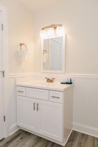 a white bathroom with a sink and a mirror at Adjacent 3rd Floor Trio, 3001 King, 3002 Queen, & 3003 Queen in Surf City
