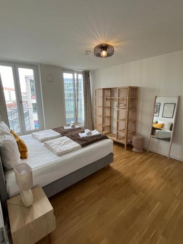 a large bedroom with a large bed and windows at UNiQE Apartments Oldtown - citycenter in Dresden