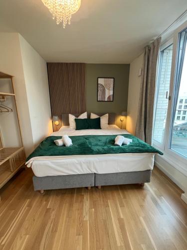 a bedroom with a large bed and a chandelier at UNiQE Apartments Oldtown - citycenter in Dresden