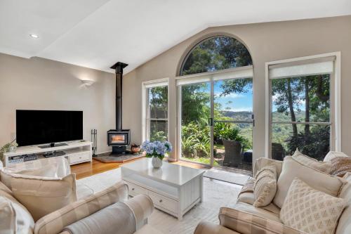 a living room with a tv and large windows at The Avenue at Montville Cottage in Montville