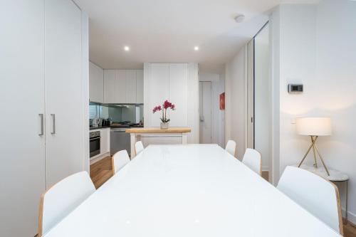 a white dining room with a white table and chairs at Convenience and Comfort in Carnegie in Carnegie