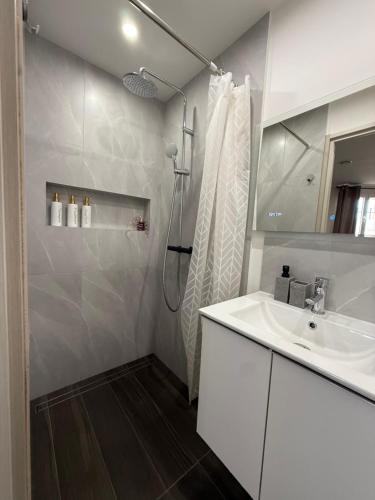 une salle de bain blanche avec un lavabo et une douche dans l'établissement Studio, Maison, rez de chaussée, Perpignan, à Perpignan
