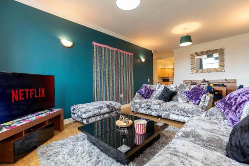 a living room with a couch and a tv at Town Centre Spacious Apartment with Private Parking in Middlesbrough