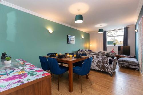 a living room with a table and blue chairs at Town Centre Spacious Apartment with Private Parking in Middlesbrough