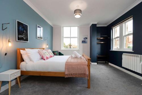 Un dormitorio con una cama con paredes y ventanas azules. en Town Centre Spacious Apartment with Private Parking, en Middlesbrough
