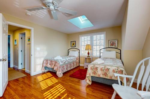 Un dormitorio con dos camas y un ventilador de techo. en South Chatham Sunshine, en South Chatham