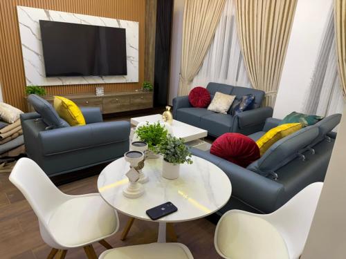 a living room with couches and a table and a tv at Luxury One bedroom Apartment R1 in Lomé
