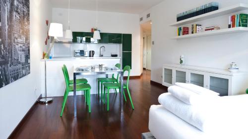 a living room with a table and green chairs at Italianway-Naviglio Pavese in Milan