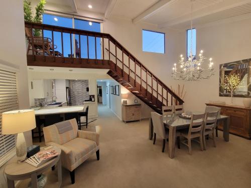 a living room with a staircase and a dining room at Luv Oceanside Views-1 House to Beach, Boardwalk and Waves-Spacious Rooftop Sun Deck-Plus King Beds too! in San Diego