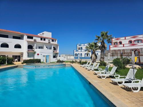 a swimming pool with lounge chairs in front of a building at Beach & House''Villa Maria'' 5 min to Mareta Beach in Sagres