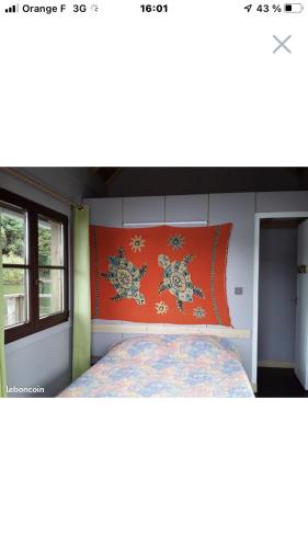 une chambre avec un lit avec une tête de lit orange dans l'établissement Les chalets flottants de Capucine, à Saint-Gérons
