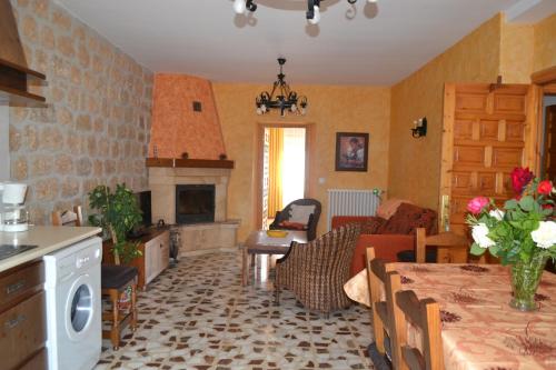 cocina y sala de estar con mesa y chimenea en Casa Rural Bocanegra, en Canicosa de la Sierra