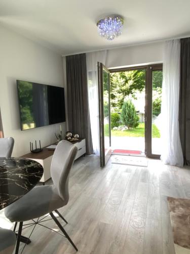 a living room with a table and chairs and a television at Luxury Apart near Lake Bohinj in Bohinj