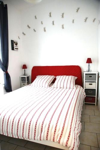 1 dormitorio con 1 cama con cabecero rojo y pájaros en la pared en Gite Escale en Ville, en Louviers