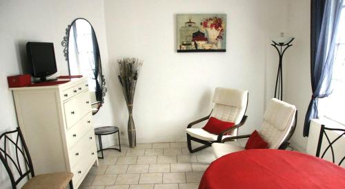 ルヴィエにあるGite Escale en Villeのリビングルーム(椅子2脚、テレビ、ドレッサー付)