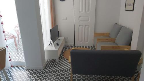 a living room with a couch and a tv at Casa 27 - Sete Rios in Lisbon