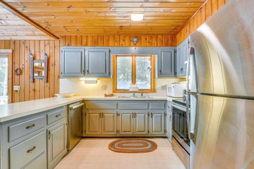 a kitchen with blue cabinets and a stainless steel refrigerator at Family-Friendly Ludlow Cabin on Lake Pauline! in Ludlow