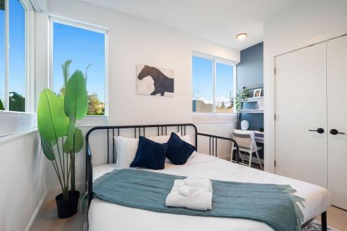 a bedroom with a bed with blue pillows and a plant at Wallingford Getaway in Seattle