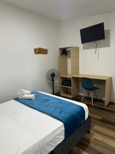Un dormitorio con una cama y un escritorio con televisión. en Travesía Quindiana, en Filandia
