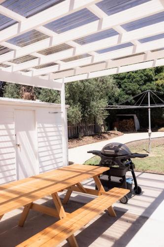 a picnic table and a grill under a white canopy at 'Sobrina=' - A home away from home in Sandy Bay in Sandy Bay