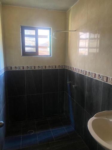 a bathroom with a shower and a sink and a window at Cabaña Paty in Mazamitla