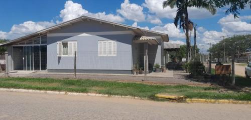 een klein wit huis aan de kant van een straat bij Casa Denis in Pântano Grande