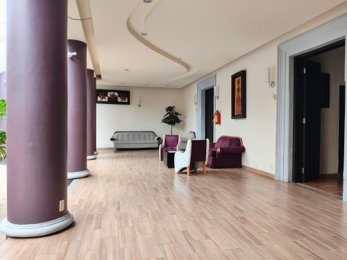 a lobby with purple columns and chairs and a couch at Hotel Jardines del Centro in San Cristóbal de Las Casas