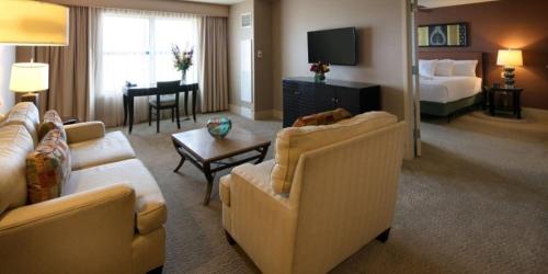a living room with two couches and a bedroom at Isle Casino Hotel Bettendorf in Bettendorf