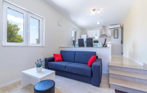 a living room with a blue couch and red pillows at Apartments Dalis in Milna