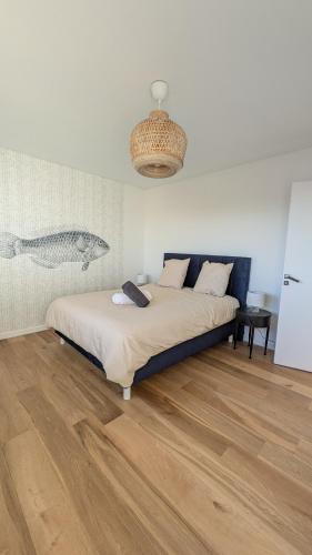 une chambre avec un lit et un parquet dans l'établissement Le Grand Large, spacieux F3 vue mer exceptionnelle avec parking, à Villers-sur-Mer