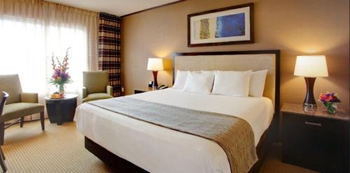 a hotel room with a large bed and a chair at Isle Casino Hotel Bettendorf in Bettendorf