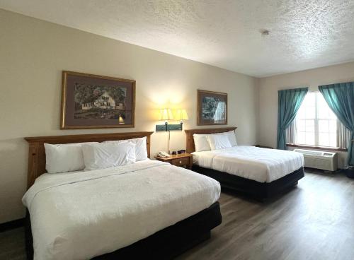 a hotel room with two beds and a window at Van Buren Hotel in Shipshewana
