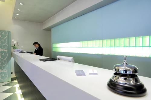 a woman sitting at a reception counter in a room at Hotel La Torretta in Bollate