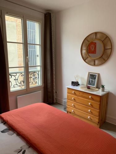 a bedroom with a bed and a dresser and a window at Le gîte entre val et rose in Provins