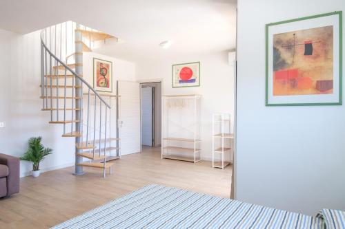 a living room with a spiral staircase in a house at Eos affittacamere in Castelsardo