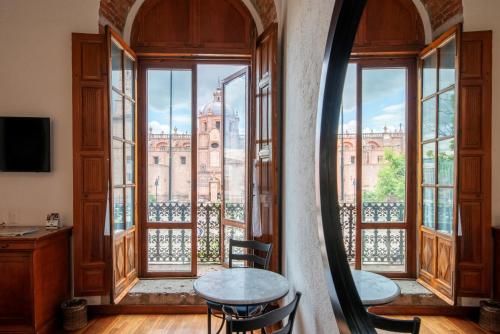 a room with a view of a building with windows at Hotel Los Juaninos in Morelia
