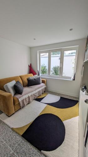 un salon avec un canapé et deux fenêtres dans l'établissement Villa Bagatelle, 8 personnes front de mer Houlgate, à Houlgate