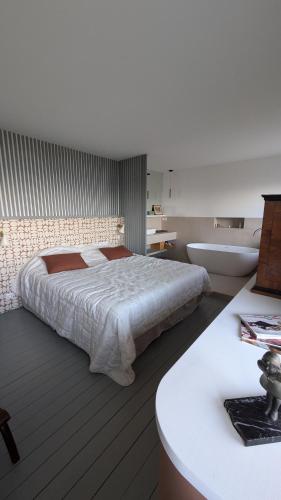 une chambre avec un grand lit et une baignoire dans l'établissement Villa Bagatelle, 8 personnes front de mer Houlgate, à Houlgate