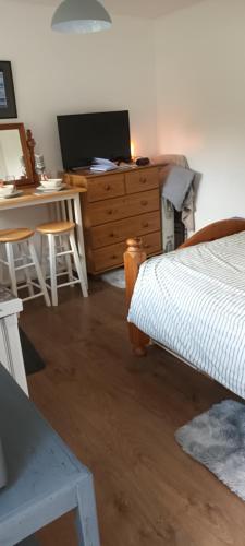 a bedroom with a bed and a desk with a computer at Robins nest in Great Hanwood