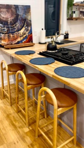 a kitchen with a wooden counter with stools around a stove at Sauger home in Saugerties