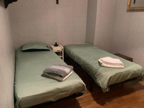 deux lits dans une chambre avec des serviettes dessus dans l'établissement Grande maison familiale à la campagne 18kms de Lyon, à Orliénas