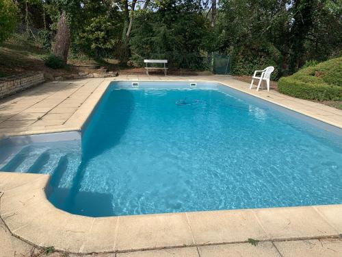une piscine bleue avec une table et une chaise dans l'établissement Grande maison familiale à la campagne 18kms de Lyon, à Orliénas