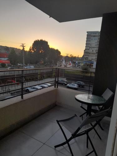 a balcony with a table and chairs and a view of a city at Grato y Bello departamento in Quilpué