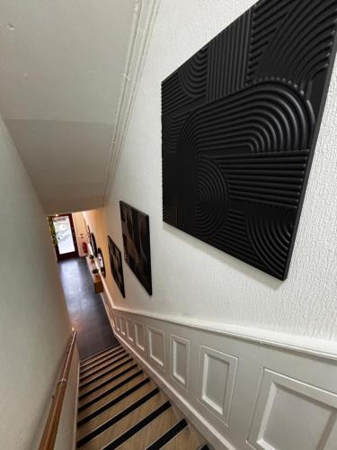 a hallway with a staircase with a large painting on the wall at Hendham House in Manchester