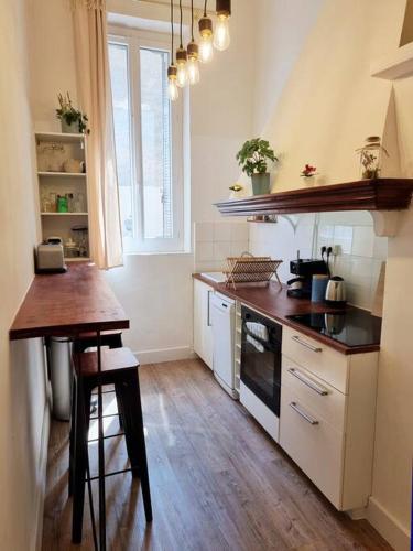 une cuisine avec un comptoir et une table à l'intérieur dans l'établissement Appartement resplendissant entre la Plaine et le Cours Julien et proche du centre-ville, à Marseille