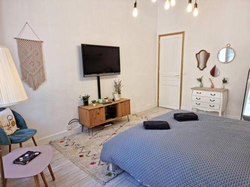 une chambre avec un lit et une télévision au mur dans l'établissement Appartement resplendissant entre la Plaine et le Cours Julien et proche du centre-ville, à Marseille